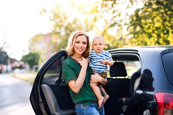 차에 의해 서 그녀의 작은 아기 아이와 젊은 어머니. — 스톡 사진