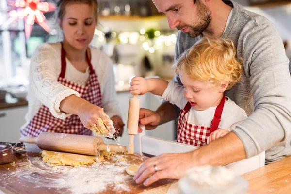 Jonge familie maken van cookies thuis. — Stockfoto