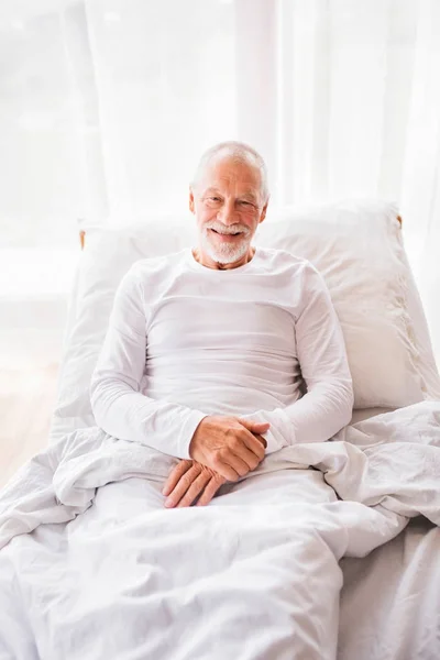 Старший мужчина лежит в постели дома . — стоковое фото