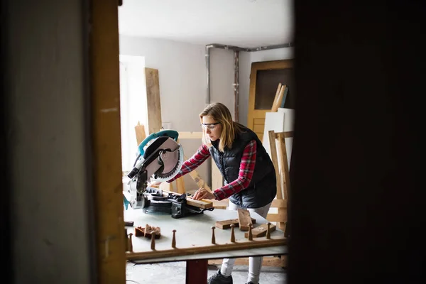 Young woman worker in the carpenter workroom. — Stock Photo, Image