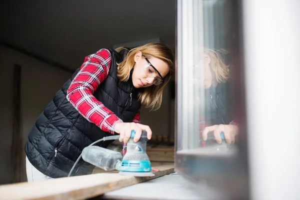 Молодая женщина, работающая в мастерской плотника. — стоковое фото