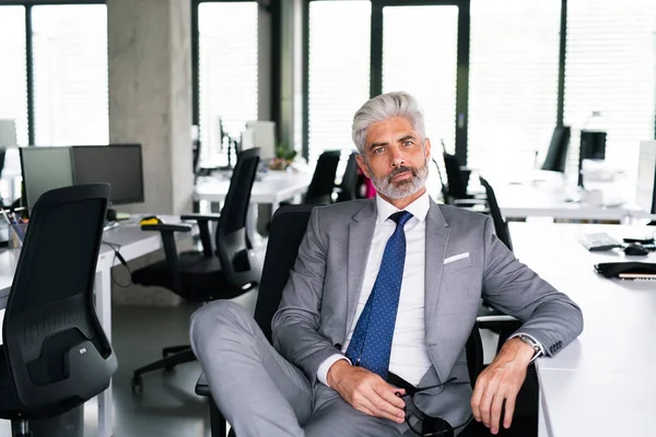 Uomo d'affari maturo in abito grigio in ufficio . — Foto Stock