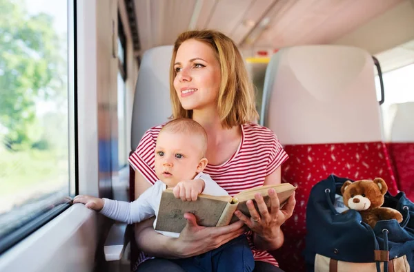 Young mother travelling with baby by train. — Stock Photo, Image