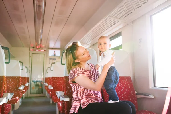Mladá matka s dítětem cestujete vlakem. — Stock fotografie