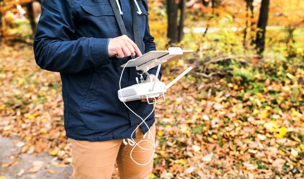Człowiek z tabletu i drone kontrolera w jesienny park. — Zdjęcie stockowe