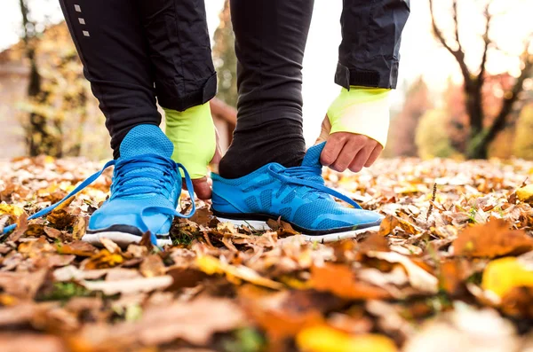 Nie do poznania młodych runner zakładanie butów sportowych. — Zdjęcie stockowe