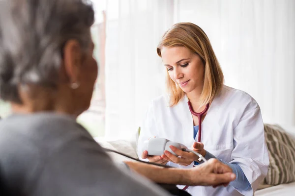 Visiteur de santé et une femme âgée pendant la visite à domicile. — Photo