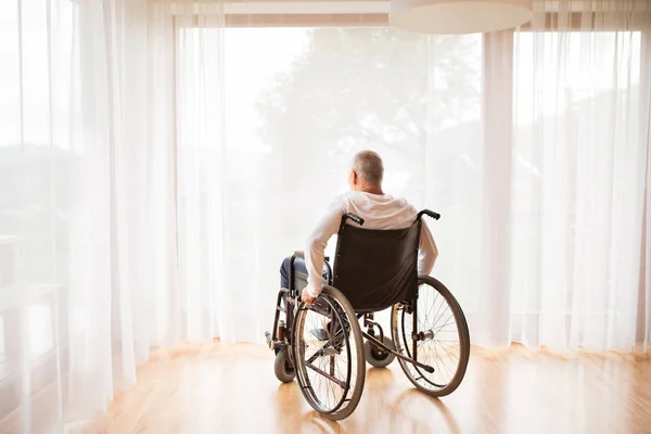 Evde tekerlekli sandalye üzerinde oturan üst düzey adam. — Stok fotoğraf