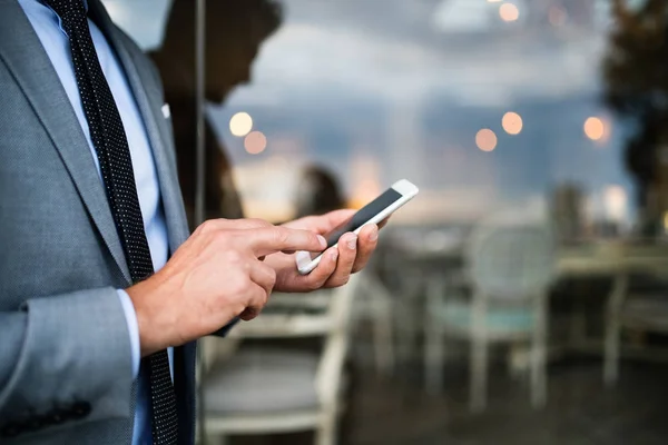 Empresário com smartphone em um café de hotel ao ar livre . — Fotografia de Stock