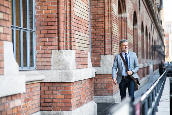 Mogen affärsman promenader i en stad. — Stockfoto