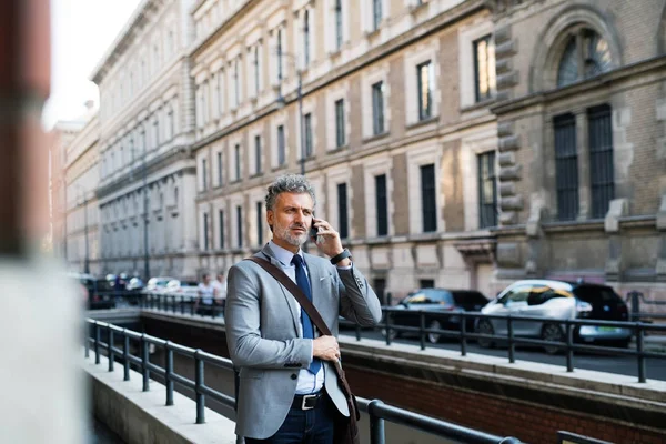 Homem de negócios maduro com smartphone em uma cidade . — Fotografia de Stock