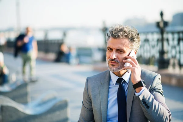 Mogen affärsman med smartphone i en stad. — Stockfoto