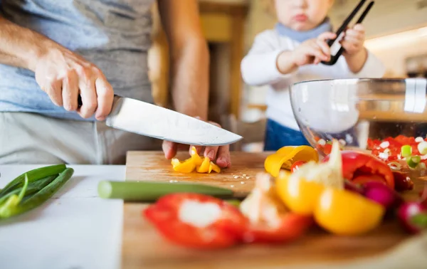 Padre joven con un niño pequeño cocinando . —  Fotos de Stock