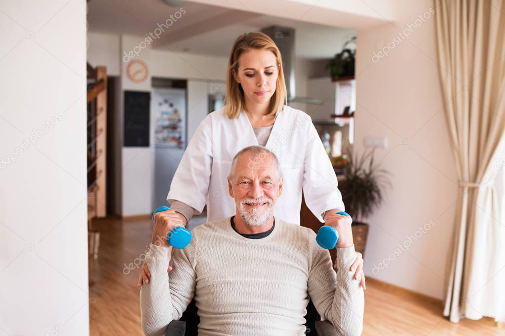 Nurse and senior man in wheelchair during home visit.