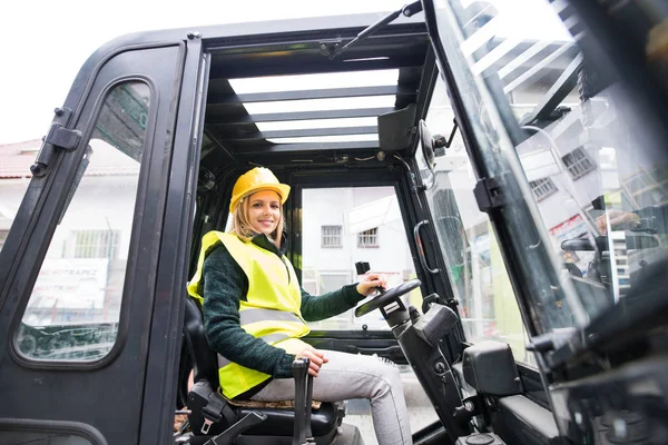 Mulher motorista de empilhadeira em uma área industrial . — Fotografia de Stock