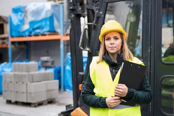 Gabelstaplerfahrerin in einem Industriegebiet. — Stockfoto