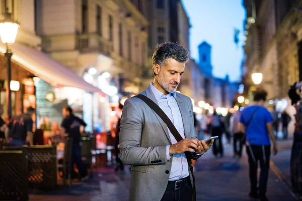Зрілий бізнесмен зі смартфоном у місті . — стокове фото