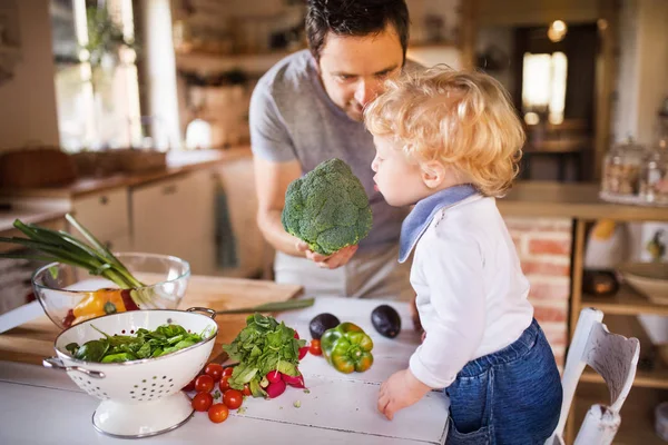 Padre joven con un niño pequeño cocinando . —  Fotos de Stock