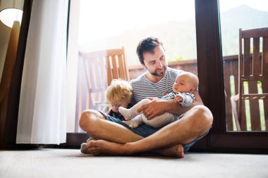 Babası bir yürümeye başlayan çocuk ve bir bebek, yaz gün holding.