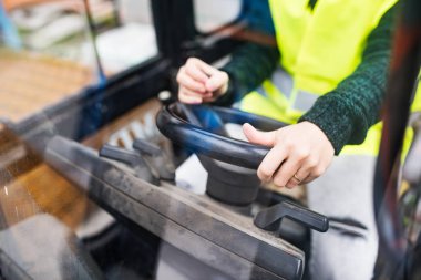 Kadın forklift kamyon şoförü bir endüstriyel alanda.