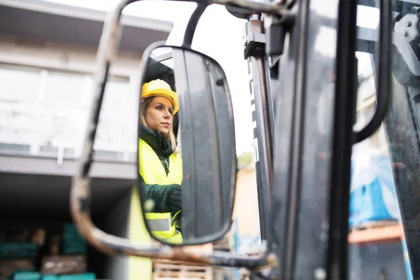 Mulher motorista de empilhadeira em uma área industrial . — Fotografia de Stock