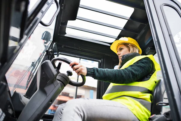 Mulher motorista de empilhadeira em uma área industrial . — Fotografia de Stock