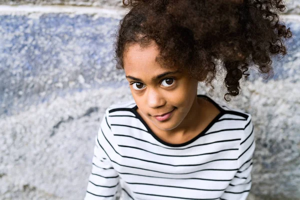 Afroamericano ragazza a righe t-shirt contro muro di cemento . — Foto Stock