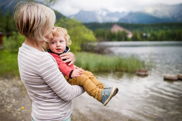 Femme âgée avec petit garçon au bord du lac, jour d'été . — Photo