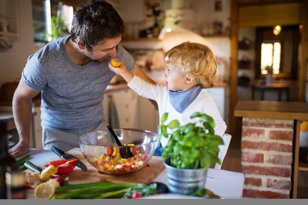 Padre joven con un niño pequeño cocinando . —  Fotos de Stock