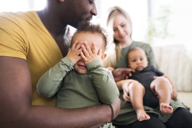 Evde küçük çocuklu genç Interracial aile.