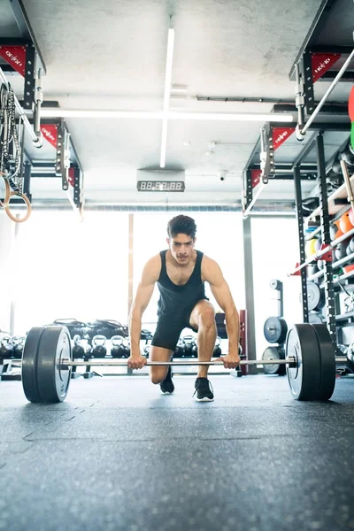 Pemuda fit hispanik pria di gym mengangkat barbel berat — Stok Foto