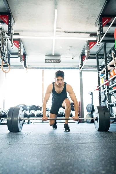 Jonge past Spaanse man in sportschool tillen van zware barbell — Stockfoto