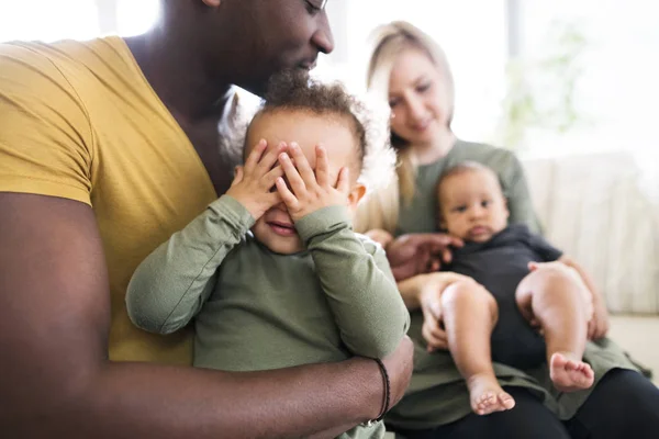 Joven familia interracial con niños pequeños en casa . —  Fotos de Stock