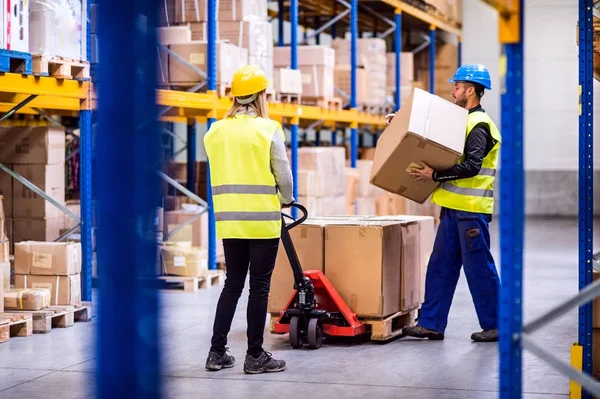 Jóvenes trabajadores en un almacén . — Foto de Stock