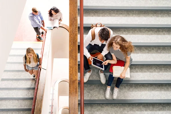 Estudiantes adolescentes en las escaleras en la escuela secundaria . — Foto de Stock
