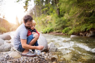 Nehirde, yaz günü küçük çocuk ile genç Baba.