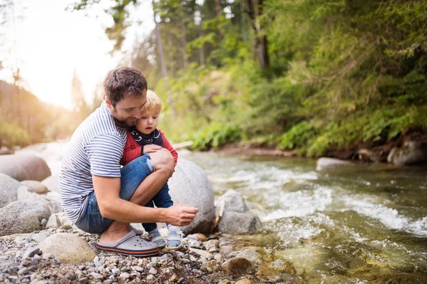 Nehirde, yaz günü küçük çocuk ile genç Baba.