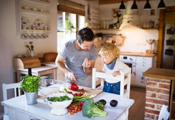 Padre joven con un niño pequeño cocinando . —  Fotos de Stock