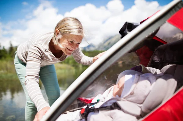 Seniorin und Enkel im Joggingwagen. — Stockfoto