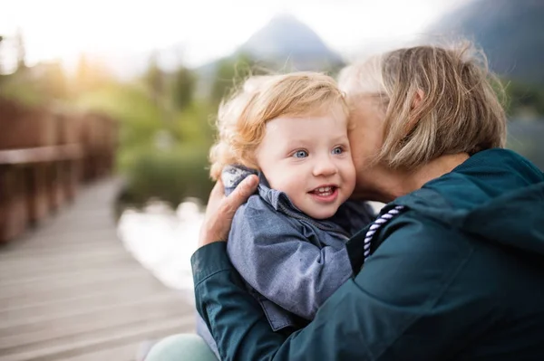 Mujer mayor con niño pequeño en el lago . — Foto de Stock