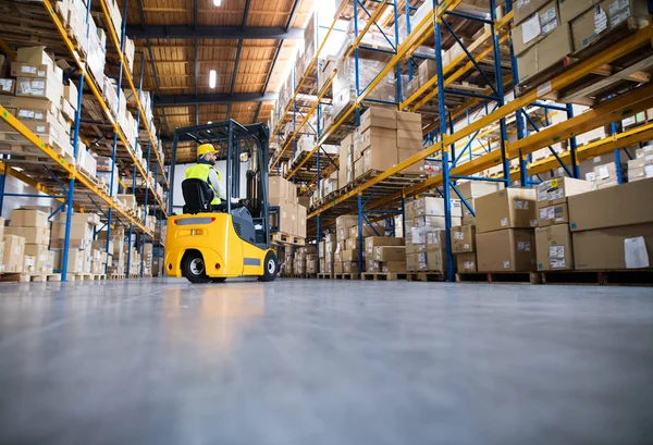 Trabajador de almacén con carretilla elevadora. — Foto de Stock