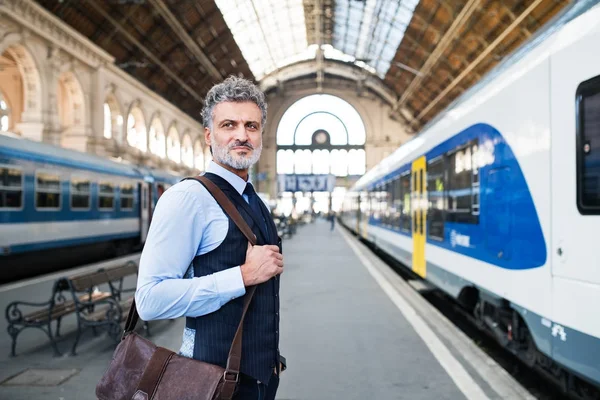 Empresário maduro em uma estação de trem . — Fotografia de Stock