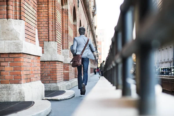 Mogen affärsman promenader i en stad. — Stockfoto