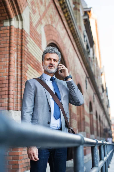 Hombre de negocios maduro con smartphone en una ciudad . —  Fotos de Stock
