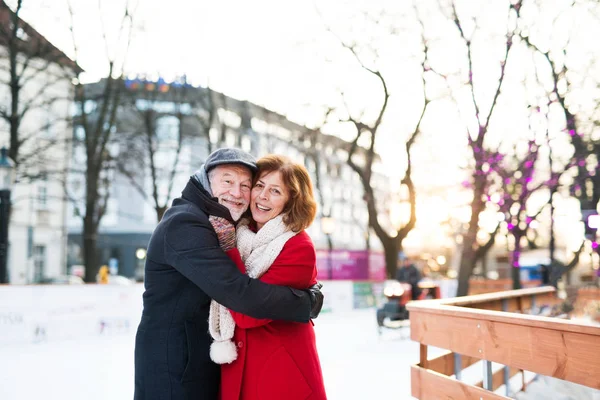 Senior paar op een wandeling in een plaats (city) in de winter. — Stockfoto