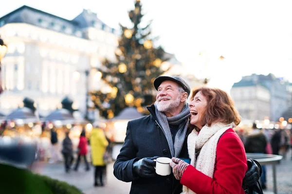 Senior couple on an outdoor Christmas market. — Stock Photo, Image
