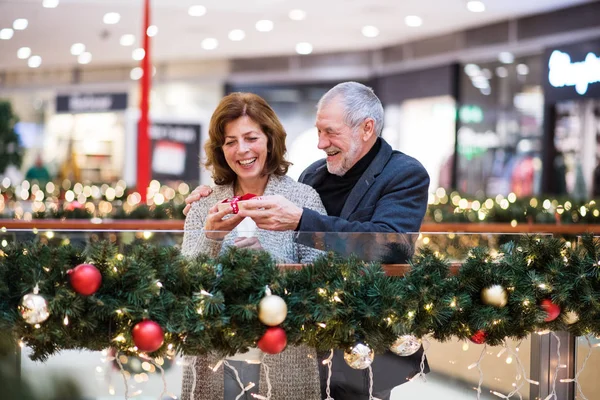 Couple aîné avec cadeau faisant des achats de Noël . — Photo