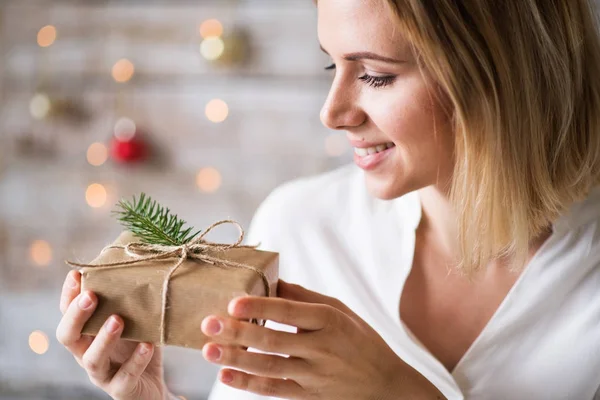 Jeune femme tenant enveloppé cadeau de Noël . — Photo