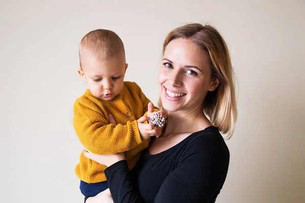 Young woman holding a toddler boy. — Stock Photo, Image