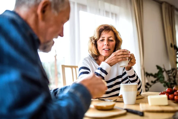 Casal sênior tomando café da manhã em casa . — Fotografia de Stock